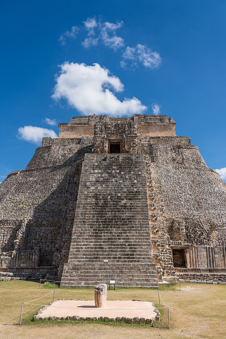 The west facade of the Pyramid of the Magician, also known as the Pyramid of the Dwarf, faces into the Quadrangle of the Birds. It is the tallest structure in the pre-Hispanic Mayan ruins of Uxmal, Mexico, rising about 35 meters or 115 feet. The temple at the top of the stairs is built in the Chenes style, while the upper temple is Puuc style.