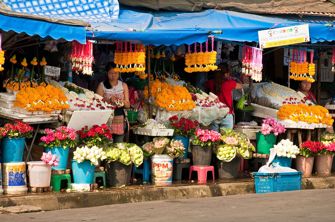 Flower vendors at marketplace near Chinatown and Ping River, Chiang Mai, Thailand.