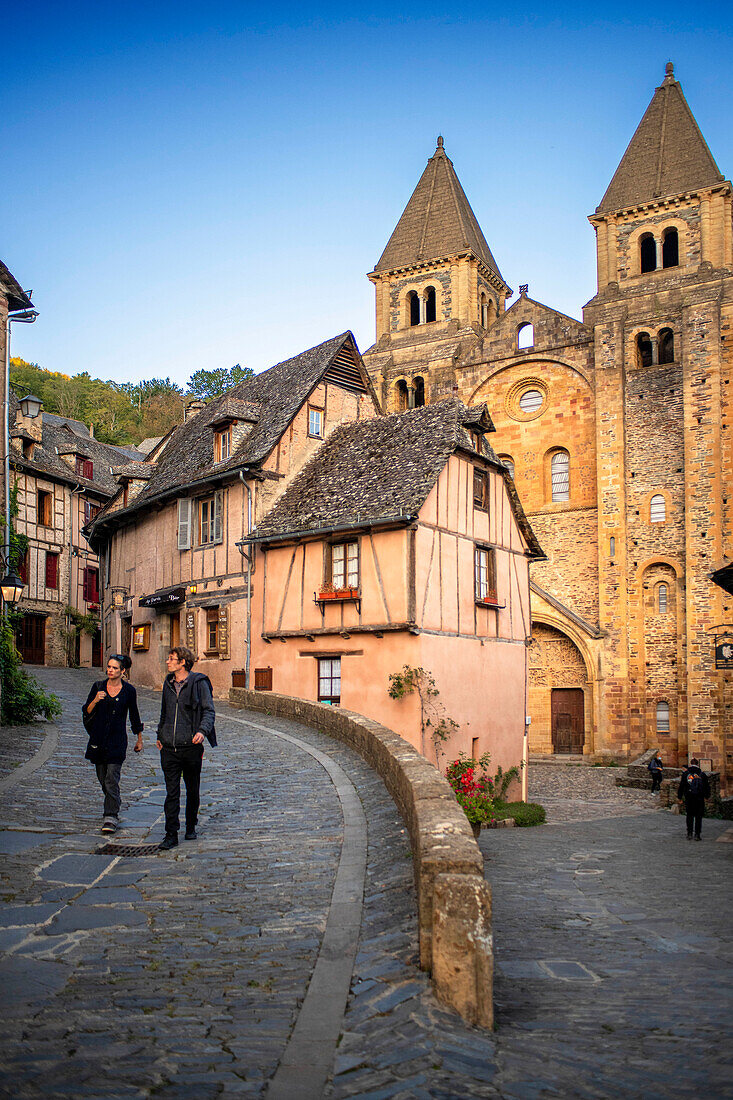 Das kleine mittelalterliche Dorf Conques in Frankreich. Es zeigt dem Besucher seine Abteikirche und die mit Schieferdächern gedeckten Häusergruppen. Durchquerung von engen Gassen und Monolithen für die Gefallenen des Krieges im alten mittelalterlichen Dorf Conques am Ufer des Flusses Dordou