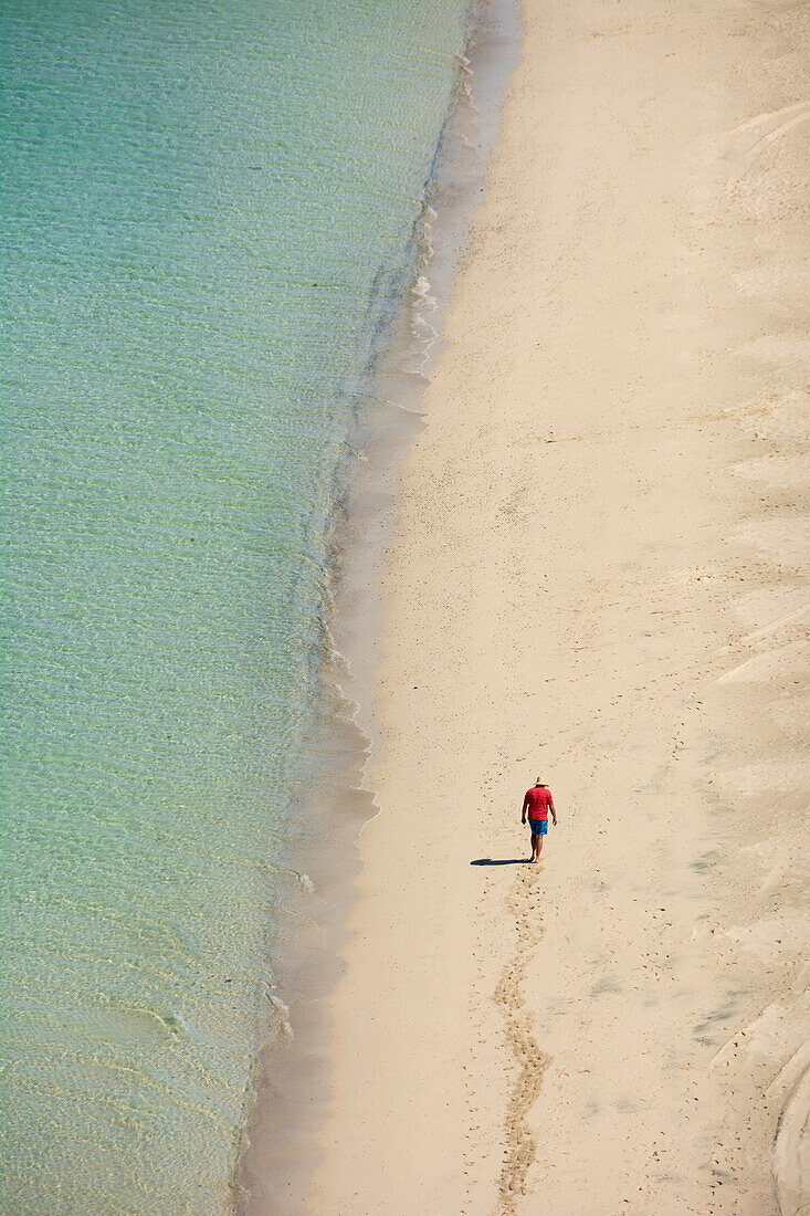 Man walking on the beach at Playa Tecolote near La Paz, Baja California Sur, Mexico.