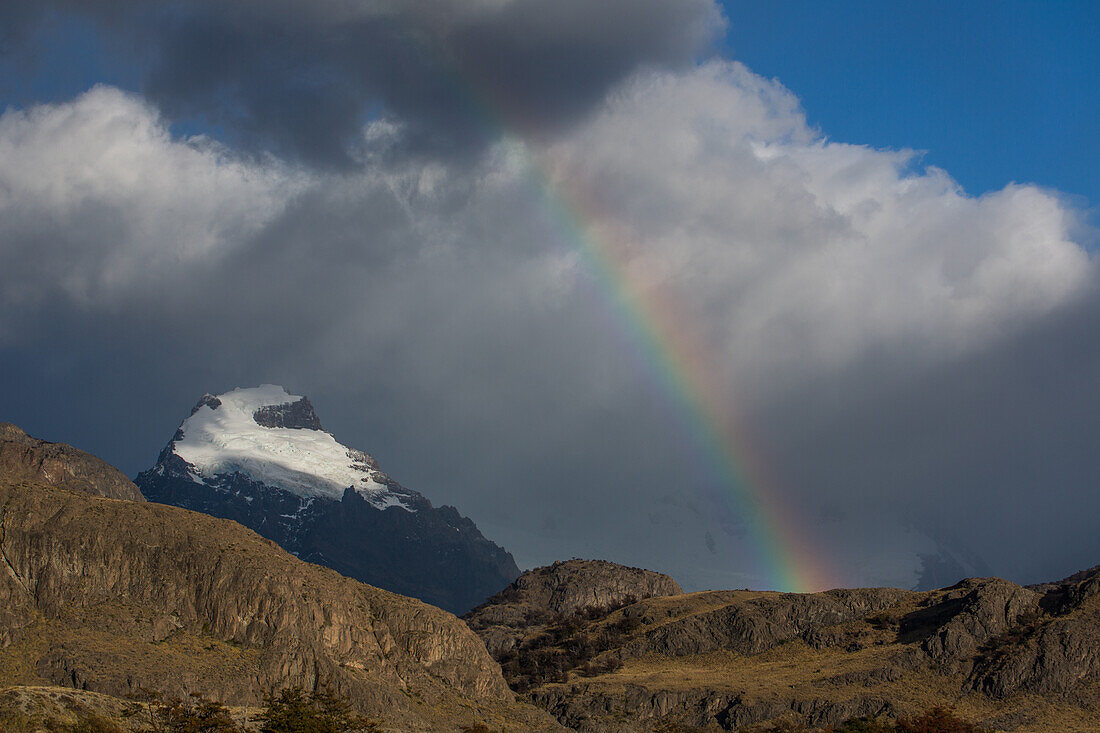 Ein Regenbogen neben dem schneebedeckten Cerro Solo im Nationalpark Los Glaciares in der Nähe von El Chalten, Argentinien, einer UNESCO-Welterbestätte in der Region Patagonien in Südamerika.