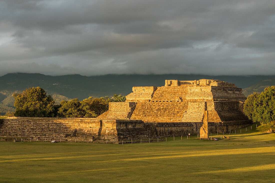 Stela 18 and the pyramids of Group IV at sunrise in the pre-Columbian Zapotec ruins of Monte Alban in Oaxaca, Mexico. A UNESCO World Heritage Site.