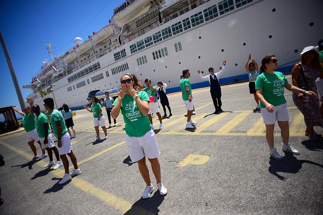 Kreuzfahrtpersonal empfängt Passagiere mit einem Tanz in Korfu, Griechenland
