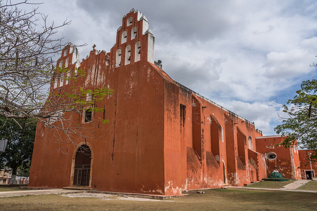 Die koloniale Kirche der Jungfrau der Himmelfahrt oder la Virgen de la Asuncion in Muna, Yucatan, Mexiko. Die Dicke der massiven Steinmauern, die um 1692 fertiggestellt wurden, lässt sich an der Tiefe des ovalen Fensters im hinteren Teil der Kirche ablesen.