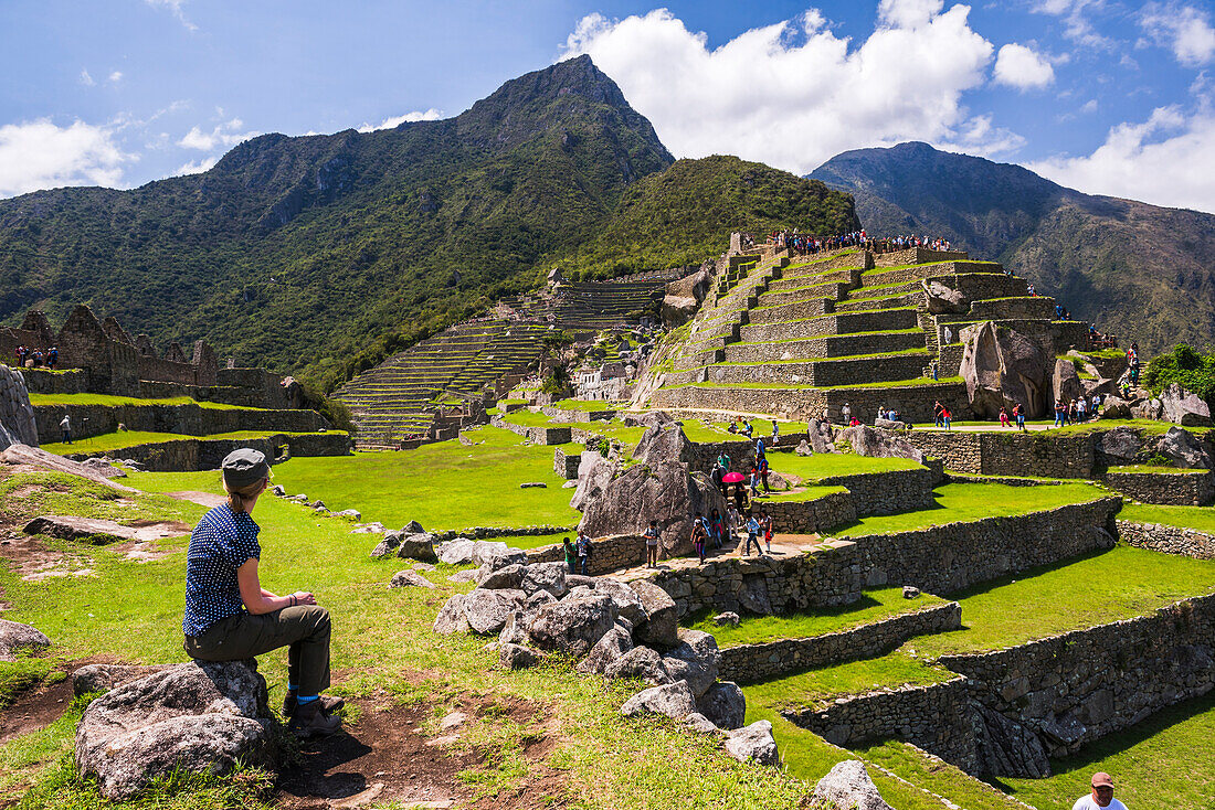 Touristen bei der Besichtigung der Inka-Ruinen von Machu Picchu, Region Cusco, Peru