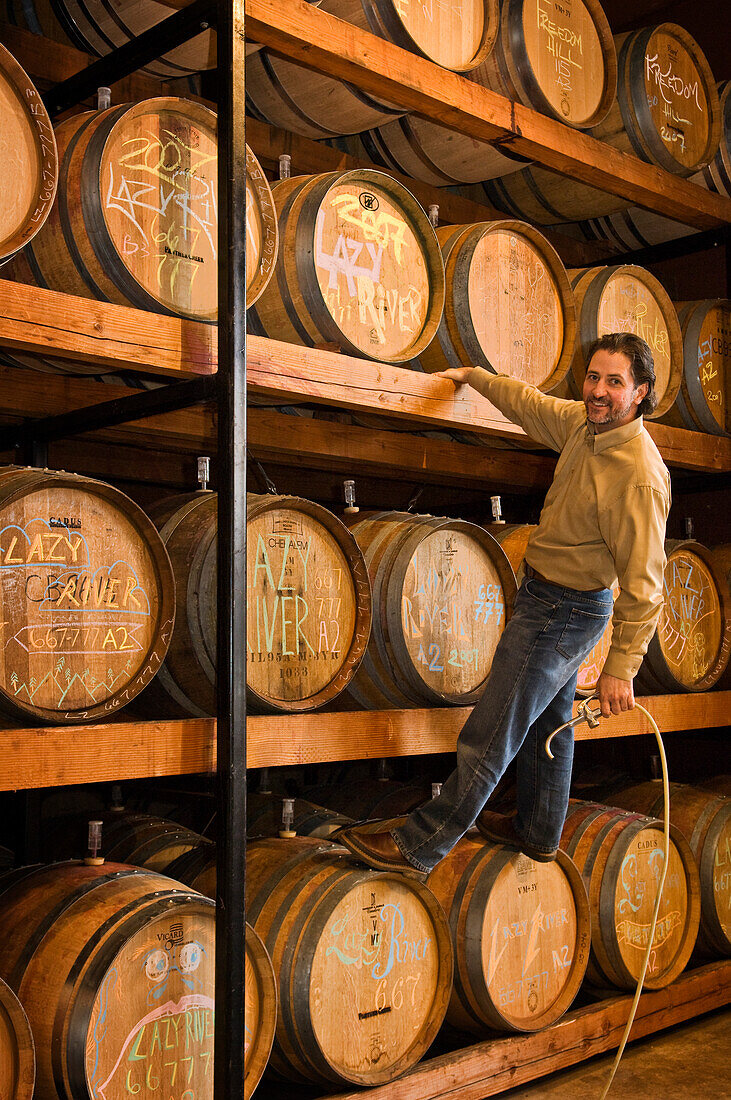 Bill Hanson, C.W.E., Panther Creek Cellars Assistant Winemaker, topping off barrels of Lazy River vineyards pinot noir; McMinnville, Oregon.