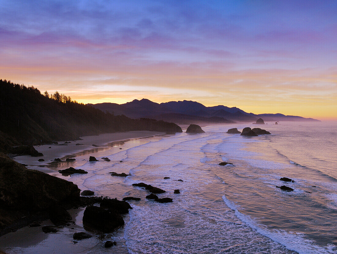 View of Crescent Beach, Cannon Beach, Haystack Rock and coast to Hug Point from Ecola State Park at sunrise; Oregon.