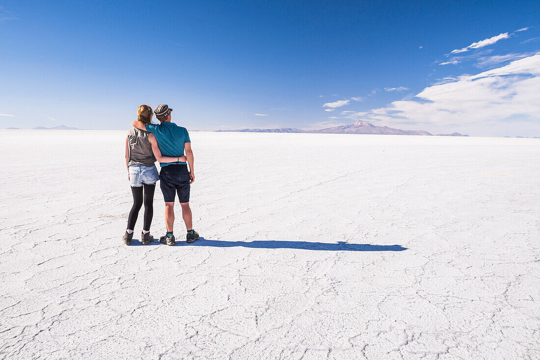 Junges Touristenpaar, das im Rahmen eines "Gap Year" die erstaunliche, einzigartige Landschaft der Uyuni Salt Flats (Salar de Uyuni), Uyuni, Bolivien, erkundet