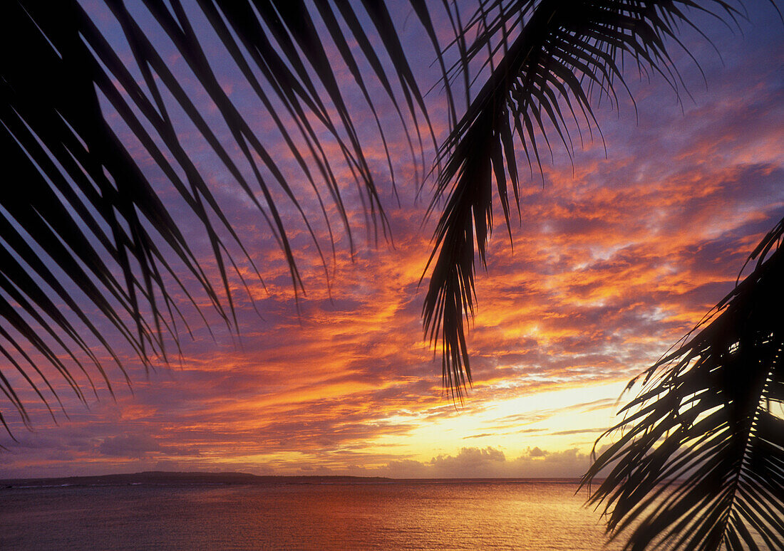 Sunset from the Pacific Islands Club resort with Tinian Island in the distance; Saipan, Northern Marianas Islands, Micronesia..