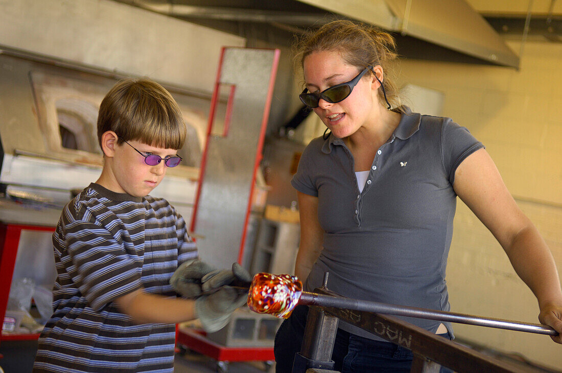 Visitor making a glass float at the Jennifer L. Sears Glass Foundry in Lincoln City on the central Oregon Coast.