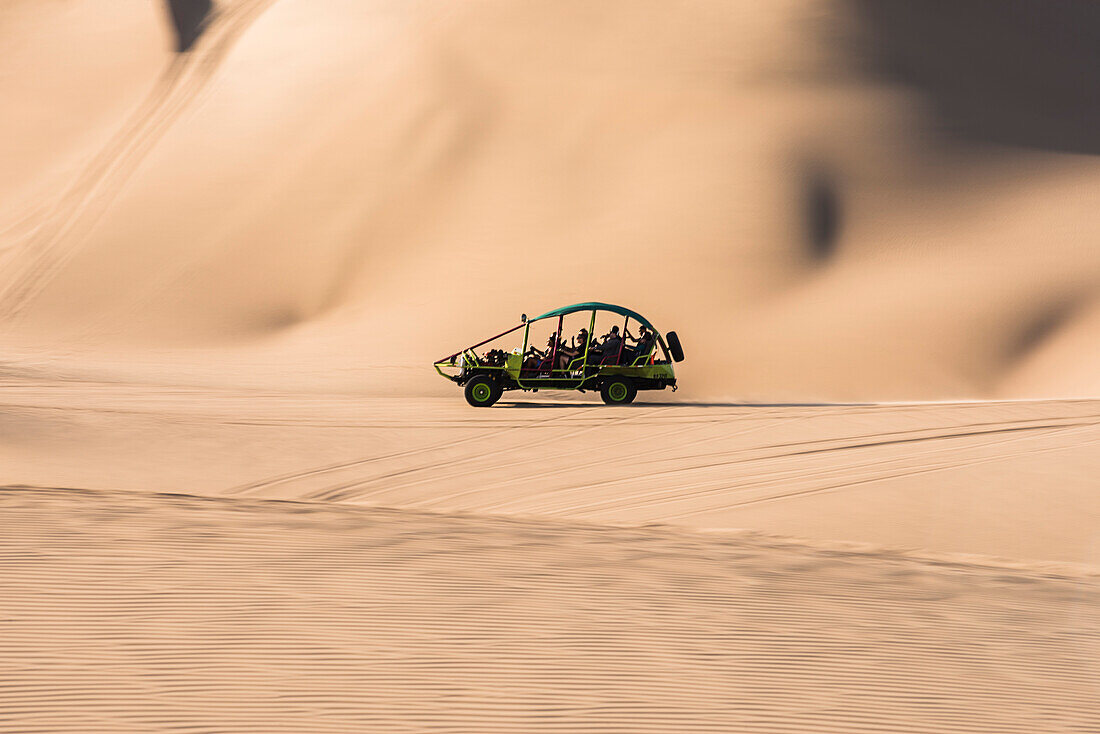 Dune buggying in sand dunes in the desert at Huacachina, Ica Region, Peru