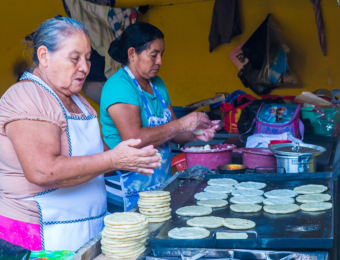 Salvadorianische Frauen bei der Zubereitung von Popusas in Suchitoto, El Salvador. Popusa ist ein traditionelles salvadorianisches Gericht, das aus Maistortilla besteht.