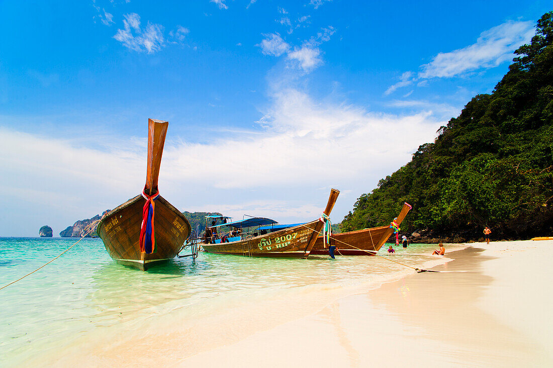 Long tail boats moored up on the white sandy beaches of Koh Phi Phi, Thailand, South-East Asia