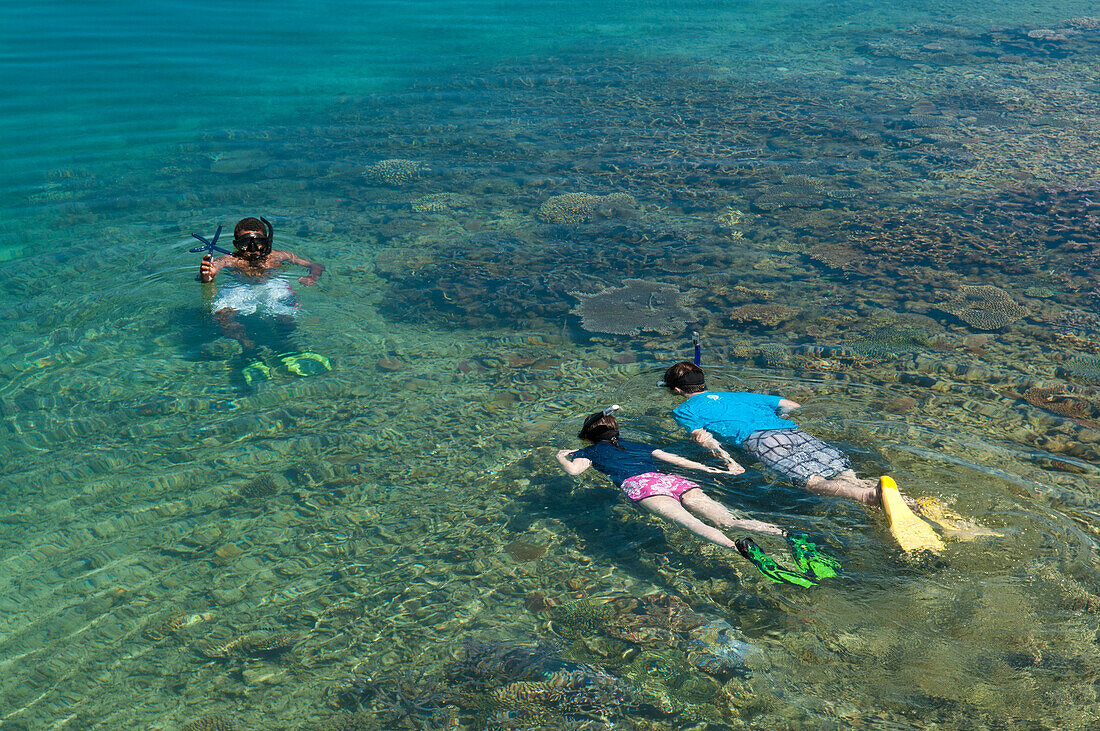 Paar in den Flitterwochen beim Schnorcheln mit örtlichem Führer am Korallenriff der Insel Taveuni während eines Besuchs bei Civa Fiji Pearls Ltd. vom Matangi Private Island Resort, Fidschi.