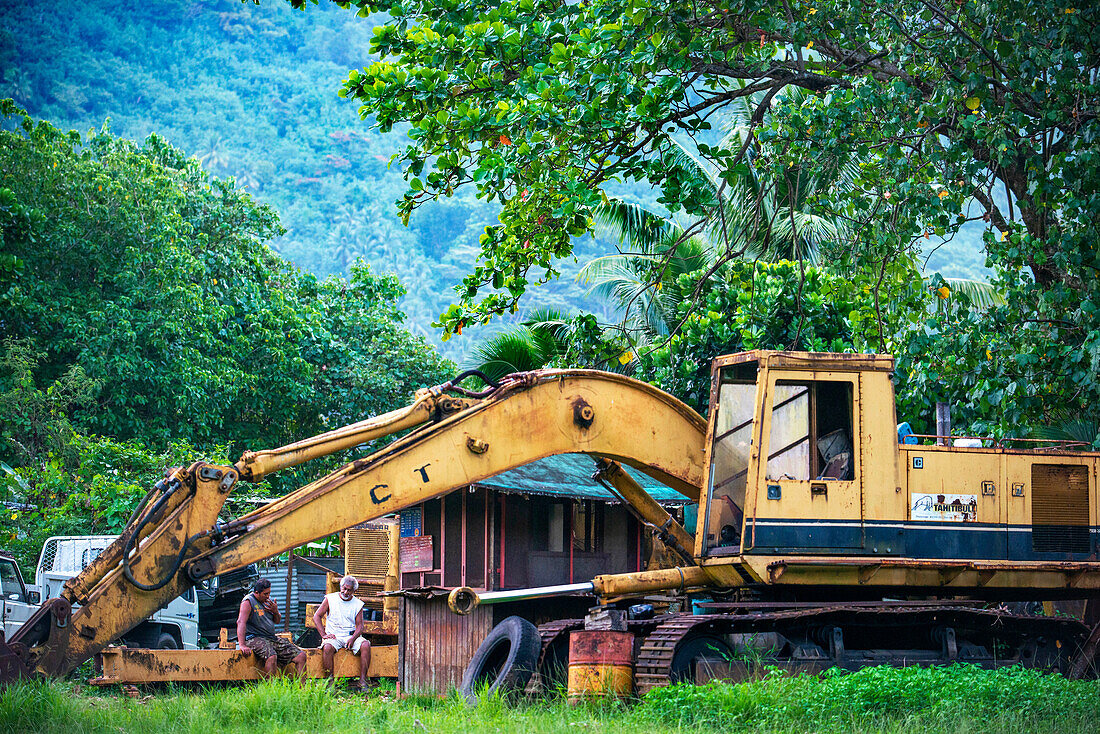 Automotive graveyard, car cemetery yard, abandoned car junkyard under trees Moorea, French Polynesia, Society Islands, South Pacific. Ecological problems