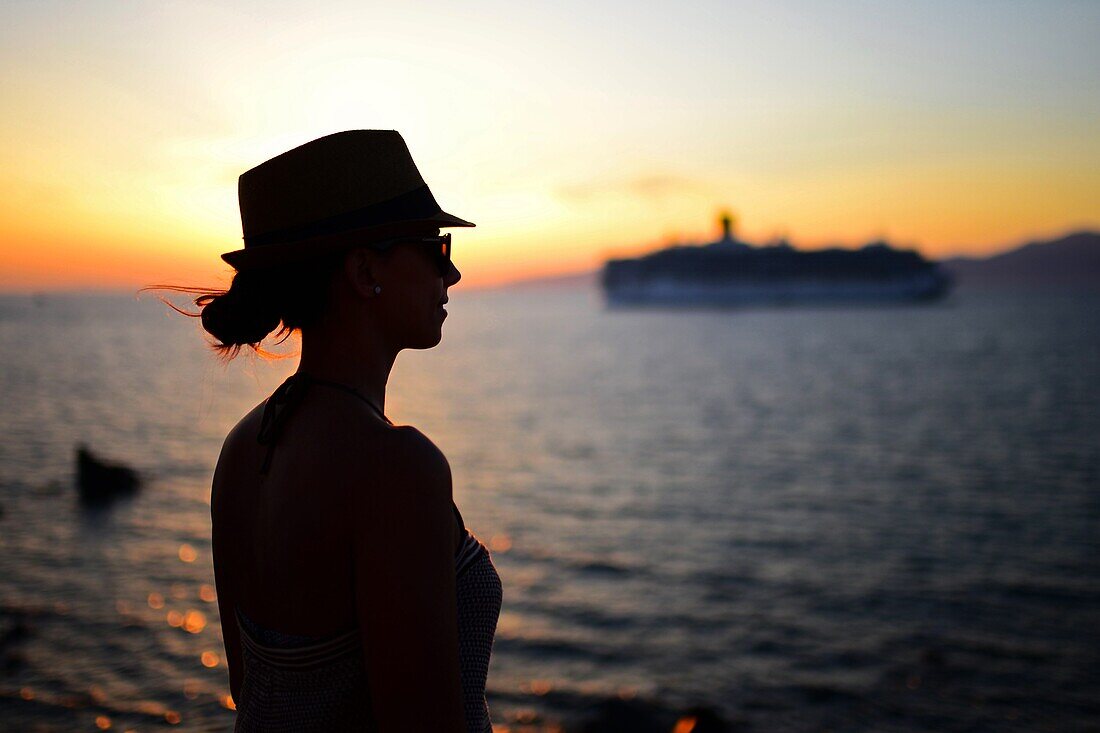 Junge Frau genießt die Aussicht auf Mykonos-Stadt bei Sonnenuntergang, Griechenland