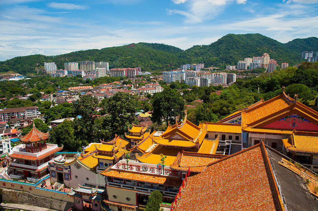 View over George Town from Kek Lok Si Temple, Penang, Malaysia. Kek Lok Si Temple is located in the Air Itam area of Penang, an easy bus ride away from the UNESCO World Heritage Site of George Town, where most tourists stay. Being the Largest Buddhist Temple in Southeast Asia, Kek Lok Si Temple is quite a spectacle with stand out features such as the Pagoda of 10,000 Buddhas and thousands upon thousands of prayers attached to chinese lanterns lining the walk to the top, where you are greeted by views back over George Town, Penang. George Town, named after King George II is a city on Penang Isl