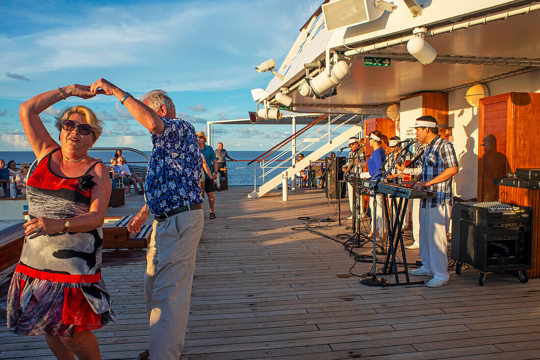 Eine Unterhaltungsgruppe singt auf dem Kreuzfahrtschiff Paul Gauguin. Frankreich, Französisch-Polynesien, Polynesien, Südpazifik.