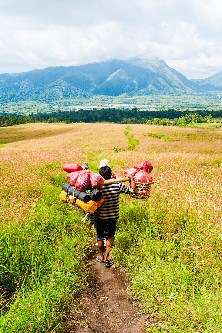 Final Leg of the Three Day Mount Rinjani Trek, Lombok, Indonesia. The sight of Senaru in the distance signals the home leg of the three day Mount Rinjani trek and brings to an end the challenging, tiring, exhausting, arduous, draining 13 hours of walking on the third and final day of the trek. Mount Rinjani (Gunung Rinjani in Indonesian) is an active volcano on Lombok island, Indonesia and its summit of 3726m, makes it the second highest volcano in Indonesia.