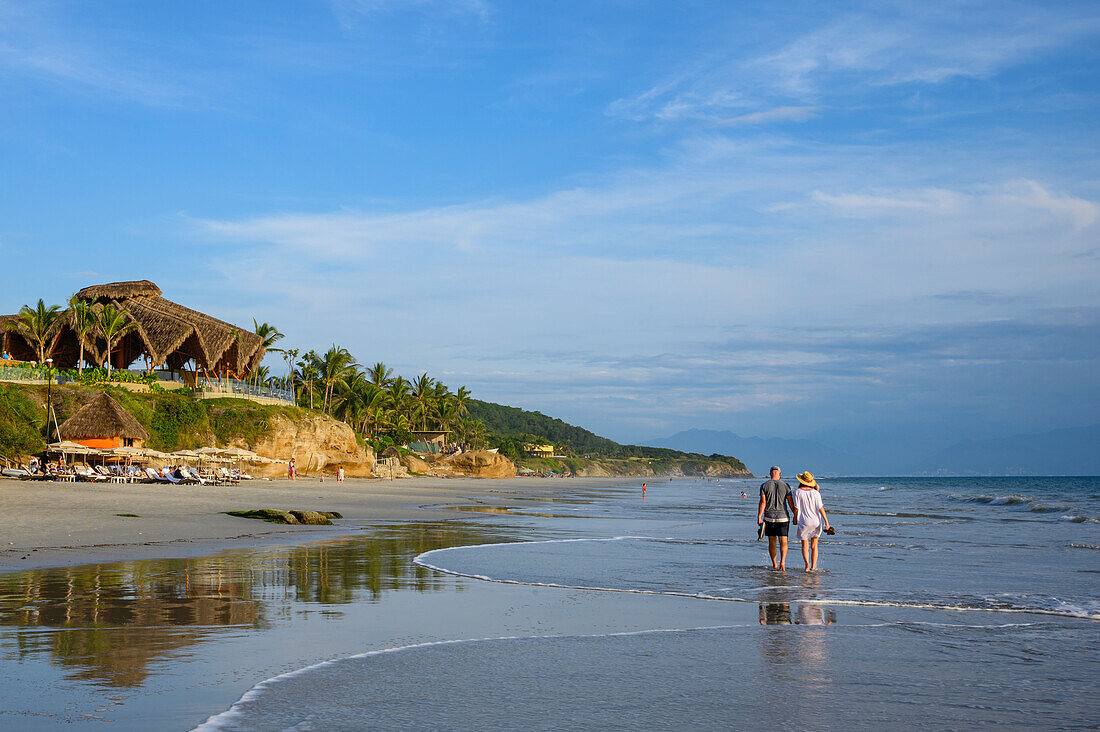 Paar beim Spaziergang an der Playa Destiladera im Marival Armony Resort, Riviera Nayarit, Mexiko. HINWEIS: Das Paar gab seine Zustimmung zu den Fotos.
