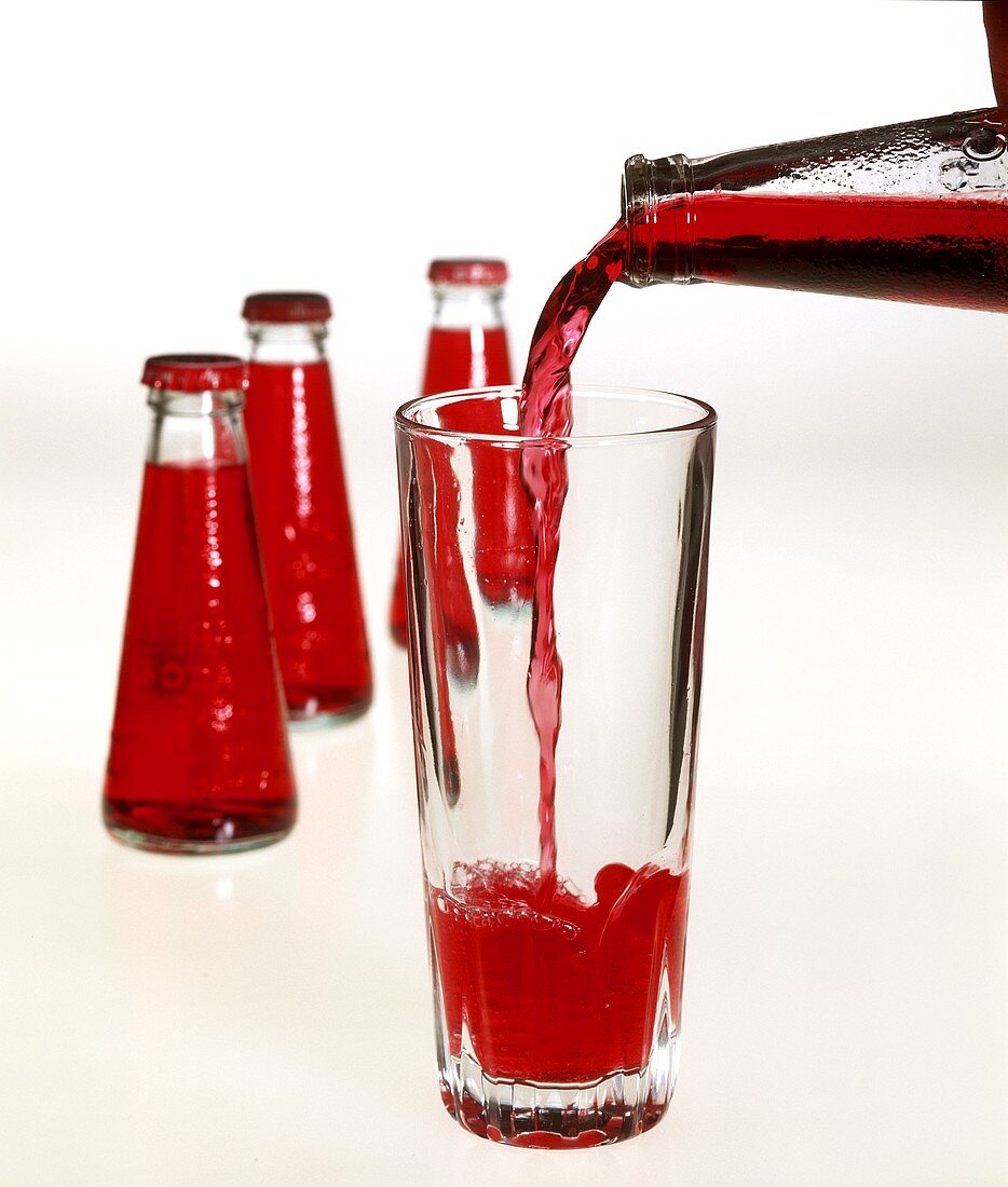 Pouring Campari Soda from a bottle into a glass