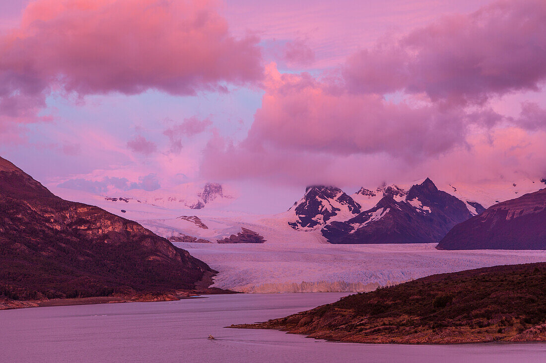 Pink skies before sunrise over the Perito Moreno Glacier in Los Glaciares National Park near El Calafate, Argentina. A UNESCO World Heritage Site in the Patagonia region of South America.
