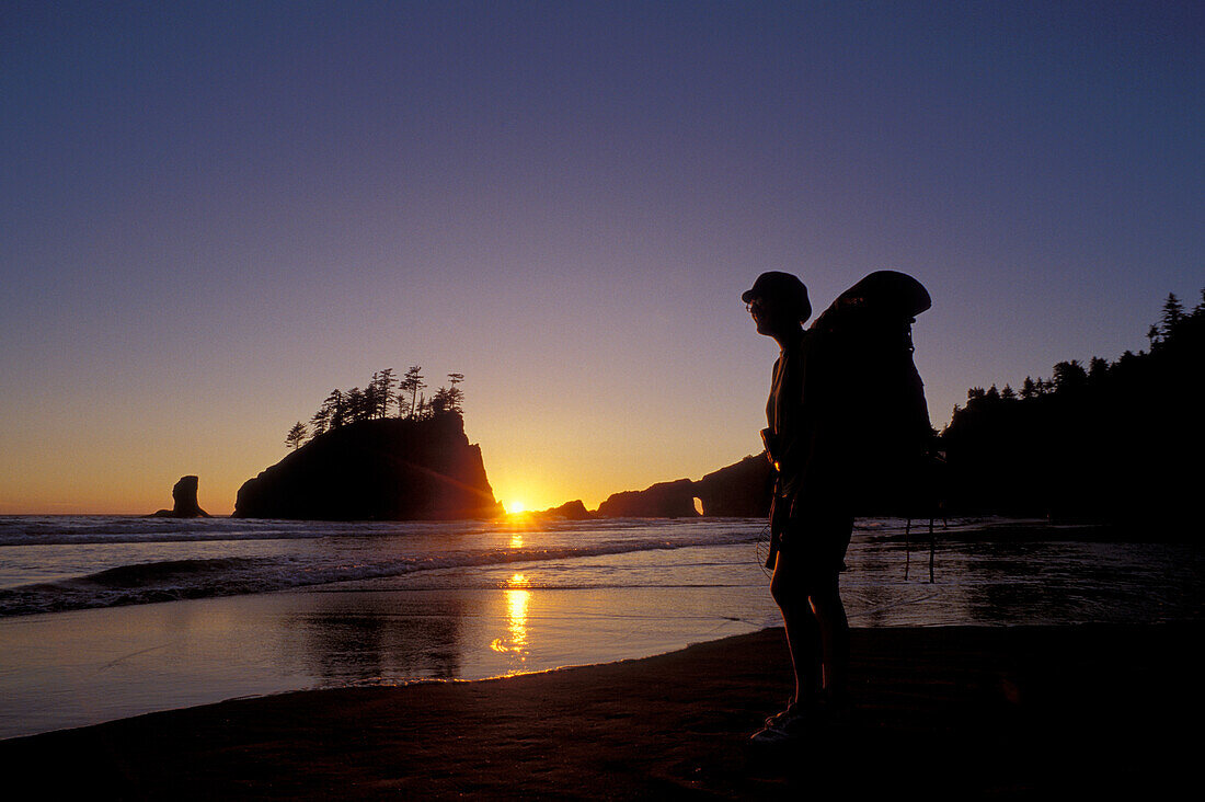 Rucksacktourist am Second Beach bei Sonnenuntergang, Olympic National Park, Washington.