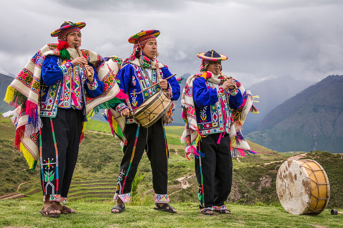 Quechua-Männer in traditioneller Kleidung mit Musikinstrumenten bei einer Aufführung im El Parador de Moray, Heiliges Tal, Peru.