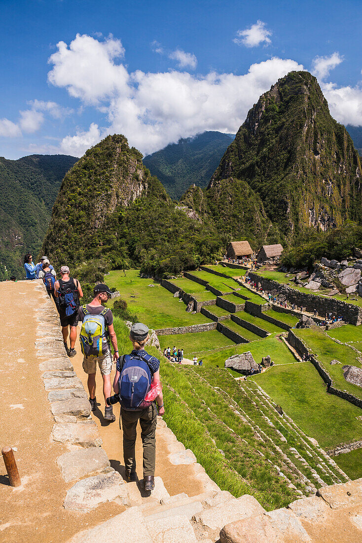 Touristen bei der Besichtigung der Inkaruinen von Machu Picchu, Region Cusco, Peru