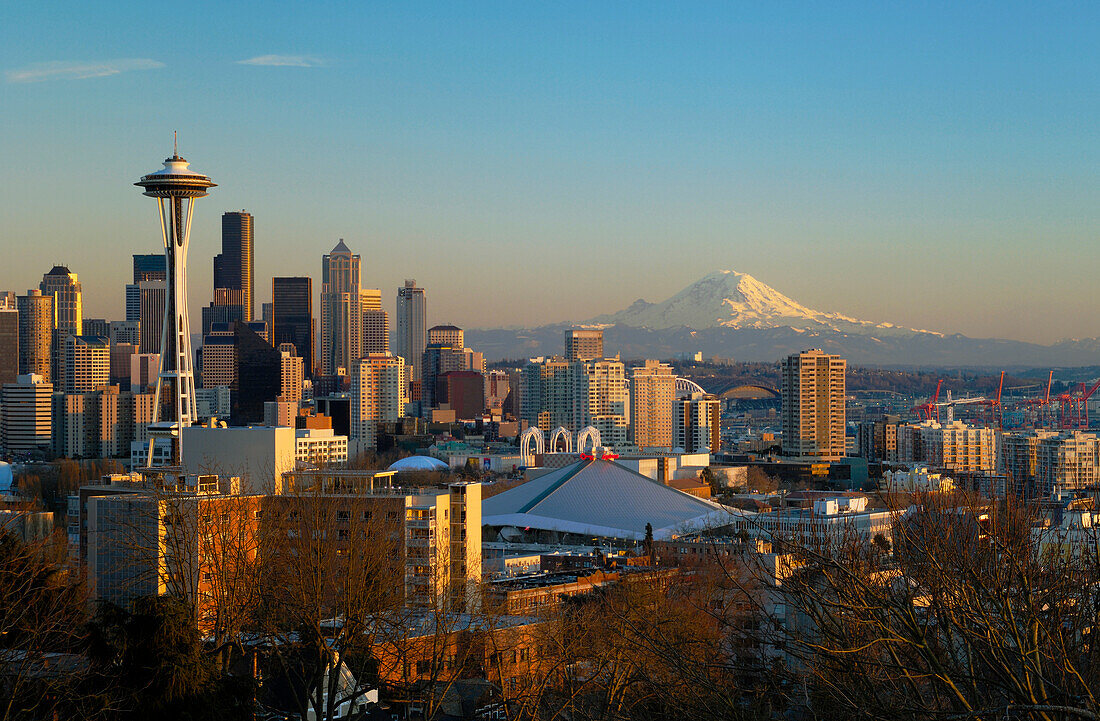 City skyline at sunset with the Space Needle, downtown and Mount Rainier from Queen Anne Hill; Seattle, Washington.