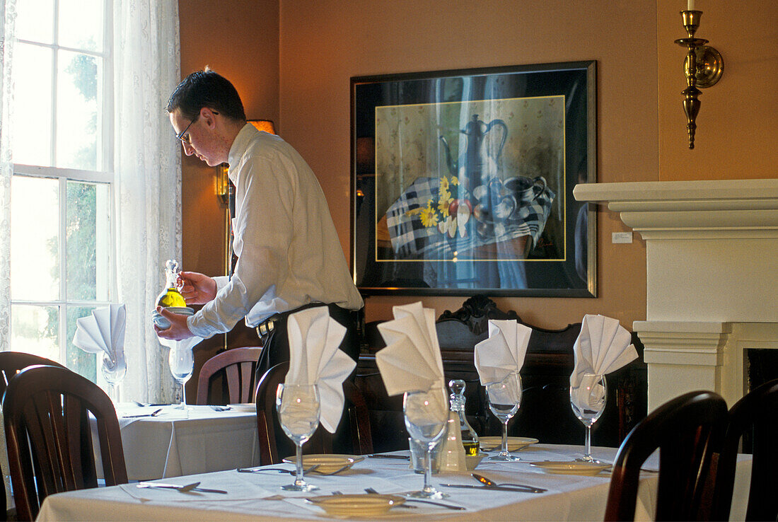 Der Kellner deckt den Tisch im Speisesaal des McCully House Inn, Jacksonville, Oregon.