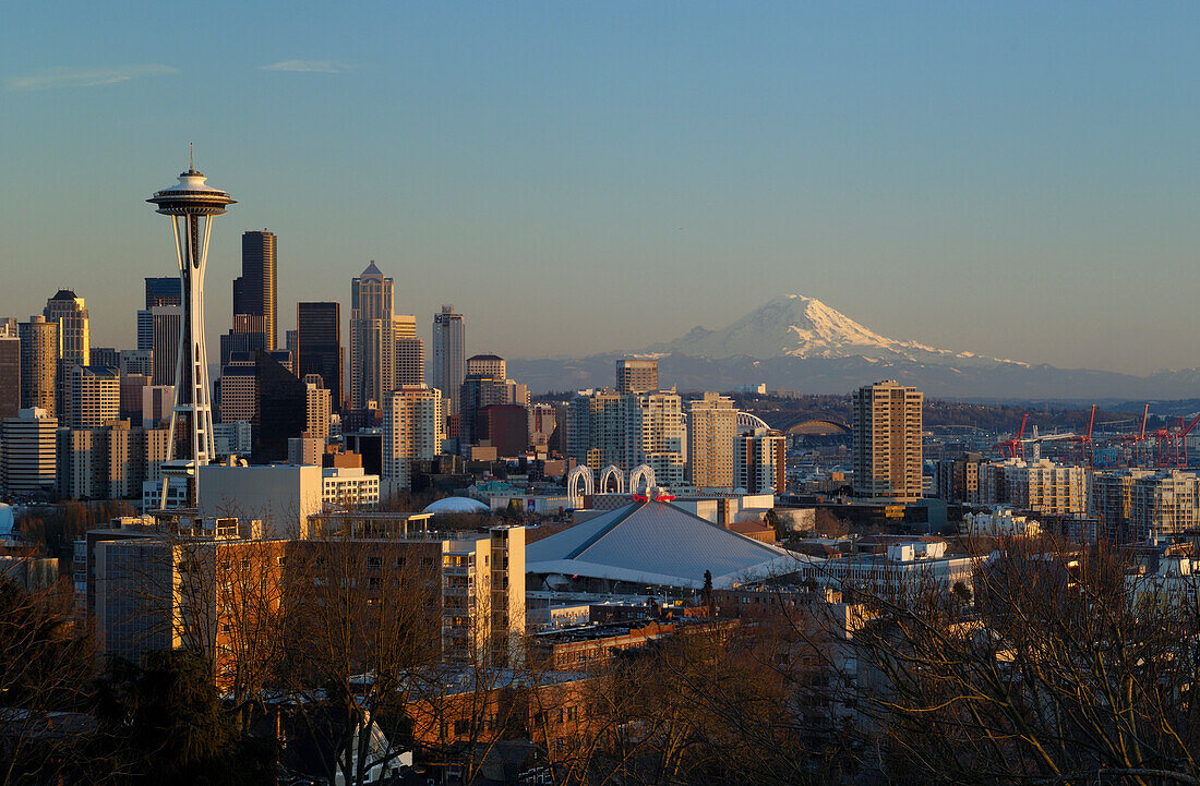 City skyline at sunset with the Space Needle, downtown and Mount Rainier from Queen Anne Hill; Seattle, Washington.