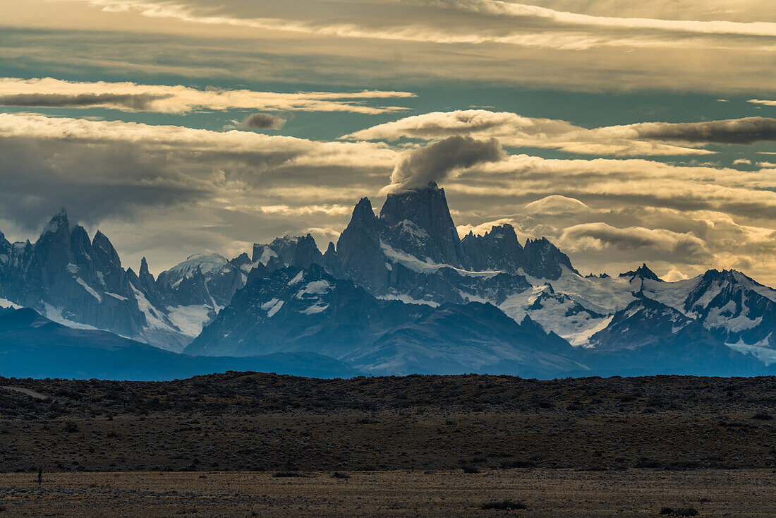The telephoto view of Mount Fitz Roy and the Fitz Roy Massif from near La Leona in Argentina. From here the mountains are almost 60 or 100 kilometers miles away. The mountains are in Los Glaciares National Park near El Chalten, Argentina. A UNESCO World Heritage Site in the Patagonia region of South America.