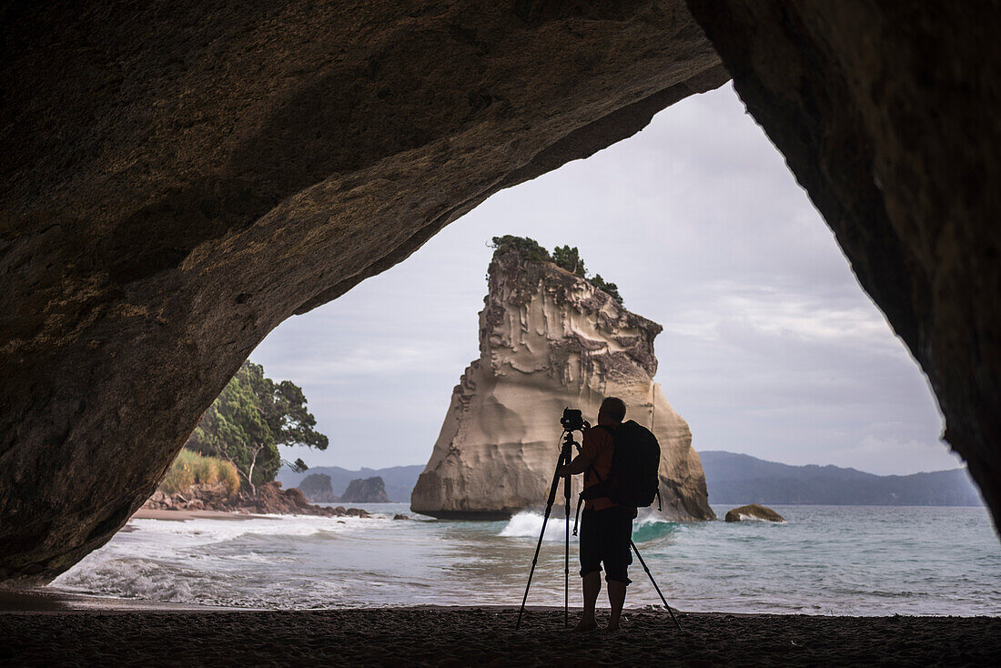 Fotograf bei der Aufnahme eines Fotos in Cathedral Cove, Coromandel-Halbinsel, Nordinsel Neuseelands