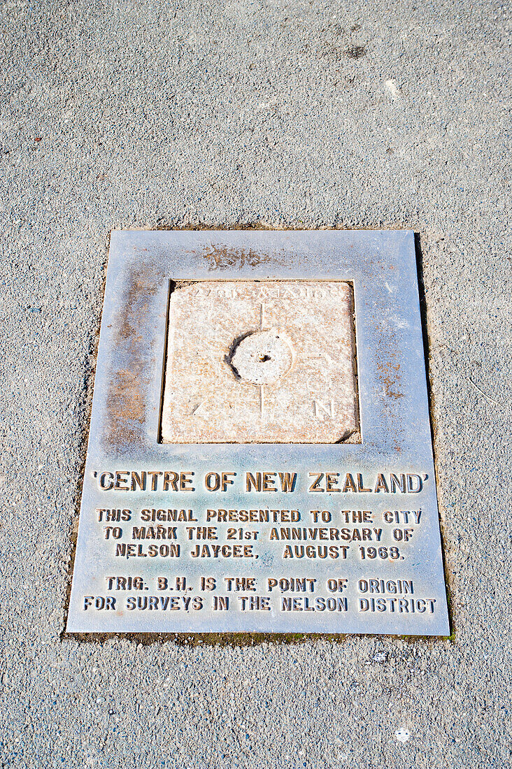 Schild "Centre of New Zealand" in Nelson, Südinsel, Neuseeland. Nelson, die Heimat des "Centre of New Zealand", ist eine sehr malerische Stadt an der Spitze der Südinsel Neuseelands. Die Lage an der Küste in Verbindung mit den umliegenden Hügeln und Bergen sorgt für eine große Vielfalt an wunderschönen Landschaften und Szenerien.