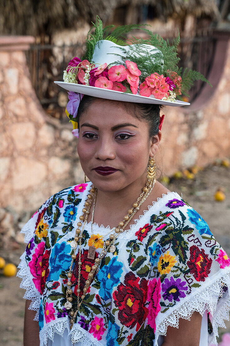 Frauen in traditionellen, festlich bestickten Huipils und geblümten Hüten bereiten sich auf den Tanz des Schweinekopfes und des Truthahns (Baile de la cabeza del cochino y del pavo) in Santa Eleana, Yucatan, Mexiko, vor. Dieser Festtanz der Maya wird nur einmal im Jahr aufgeführt.