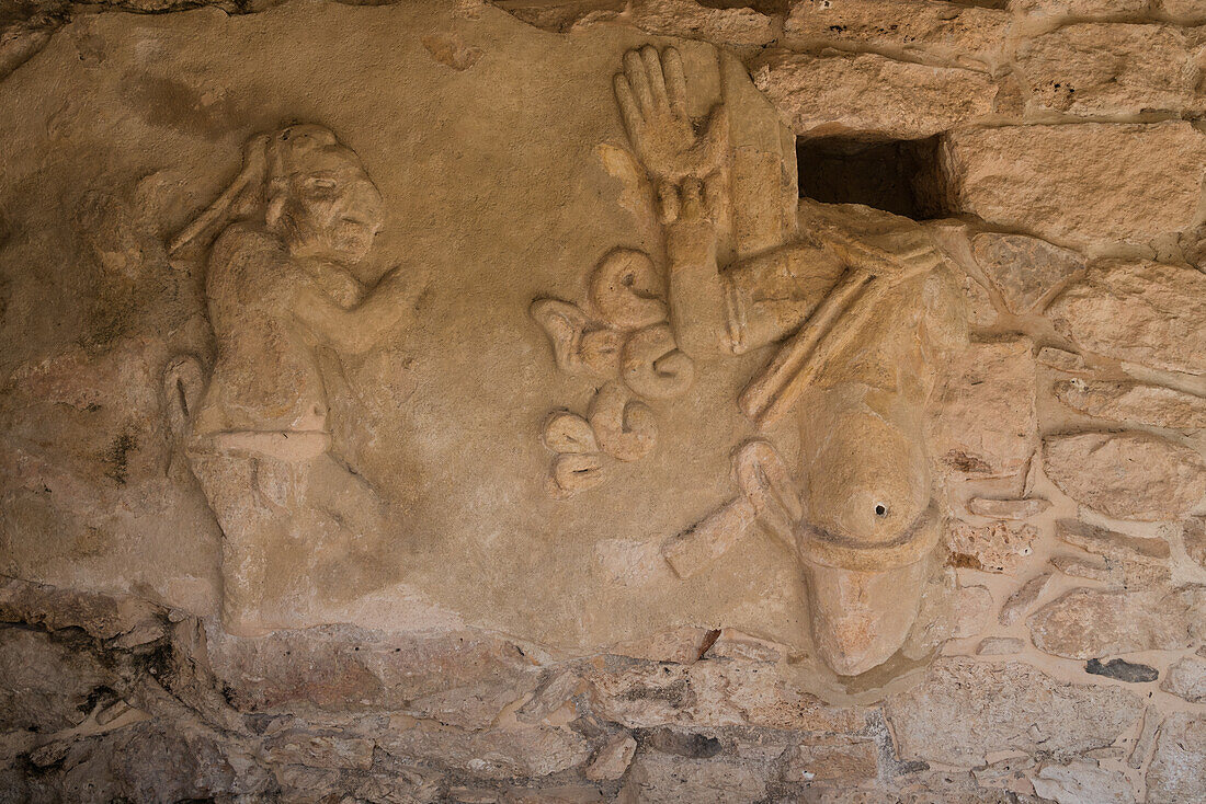 Ein Krieger in einem Stuckfries des Kukulkan-Tempels in den Ruinen der postklassischen Maya-Stadt Mayapan, Yucatan, Mexiko. Der Figur fehlt der Kopf; an seiner Stelle befindet sich eine Nische, in die der Kopf oder Schädel eines Opferopfers gelegt wurde.