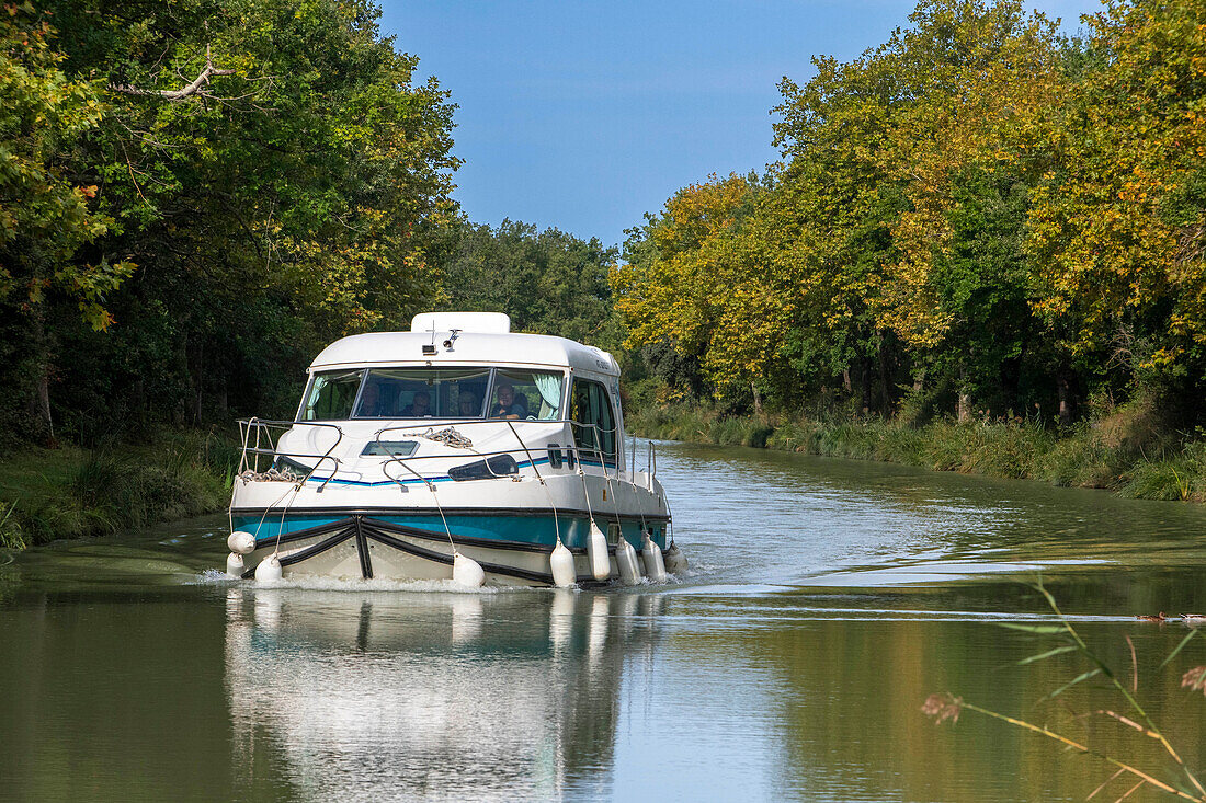 Der Canal du Midi, in der Nähe von Carcassonne, französisches Departement Aude, Region Occitanie, Languedoc-Rousillon Frankreich. Boote, die auf dem von Bäumen gesäumten Kanal vertäut sind. Die Herminis-Schleuse oder Herminis ecluse.
