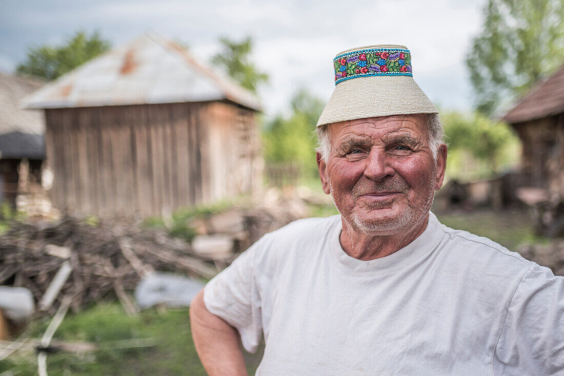 Porträt eines Mannes mit einem traditionellen Maramures-Hut in Breb (Brebre), Maramures, Rumänien