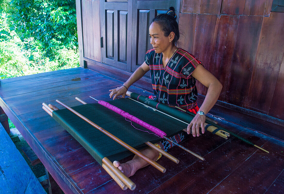 Frau aus der Cotu-Minderheit webt mit einem Riemenwebstuhl in Quang Nam, Vietnam