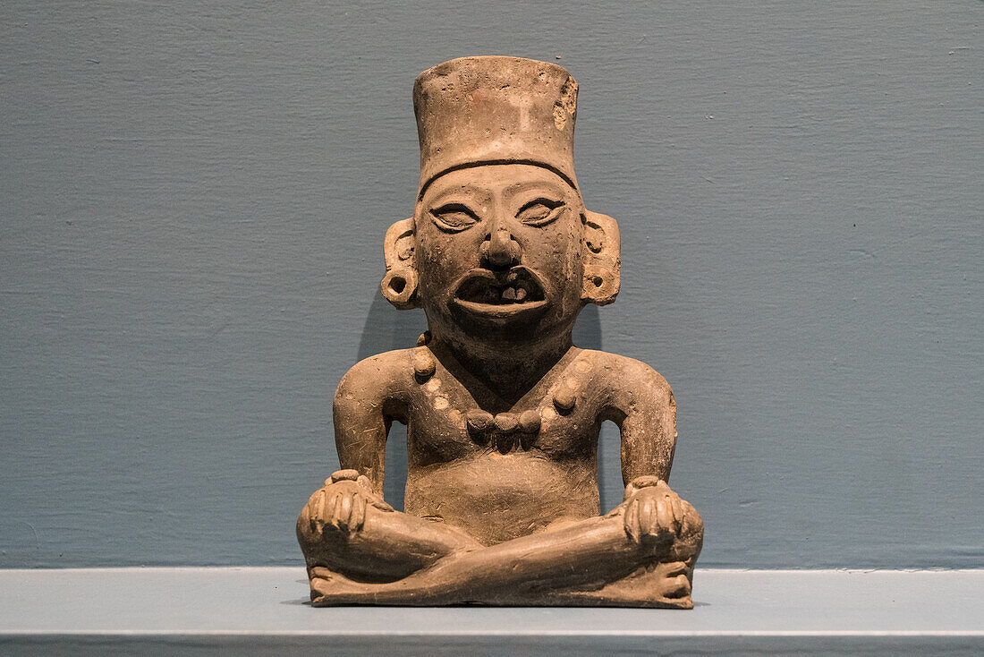 Eine Graburne in Form eines sitzenden Mannes im Museum der Stätte Monte Alban, Oaxaca, Mexiko. Eine UNESCO-Welterbestätte.