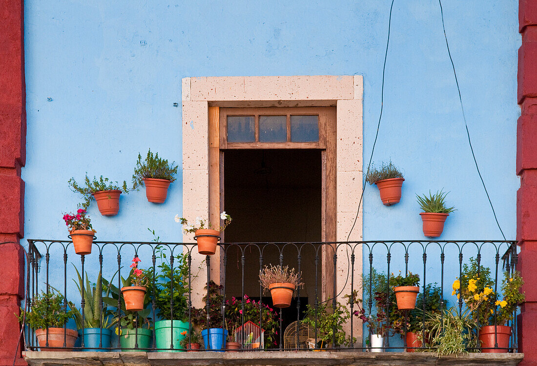 Blumentöpfe auf dem Balkon einer Wohnung in der Innenstadt von Guanajuato, Mexiko.