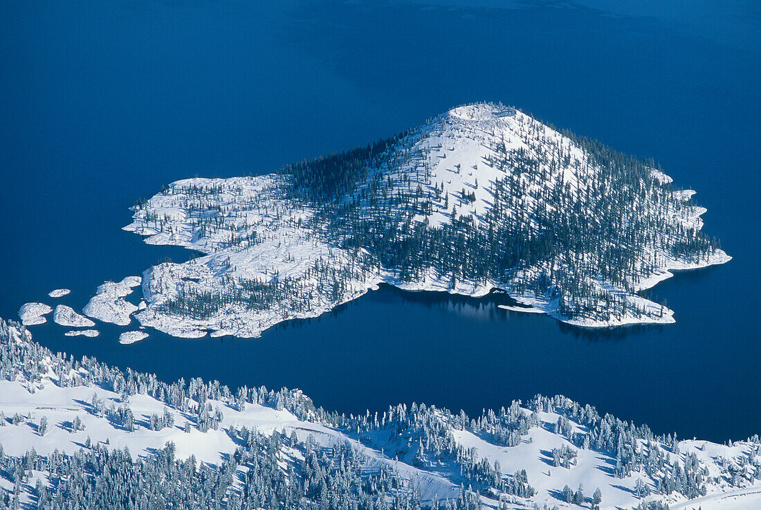 Wizard Island and Crater Lake in winter snow; Crater Lake National Park, Oregon, USA.
