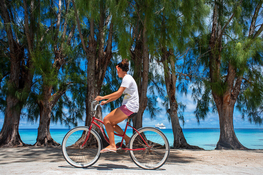 Einheimisches Mädchen mit einem Fahrrad in Fakarava, Tuamotus-Archipel, Französisch-Polynesien, Tuamotu-Inseln, Südpazifik.