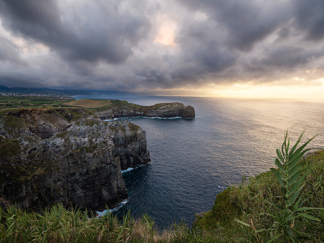 Sunset over the ocean in a cloudy day seen from Miradouro do Cintrao, Sao Miguel island, Azores islands, Portugal, Atlantic Ocean, Europe