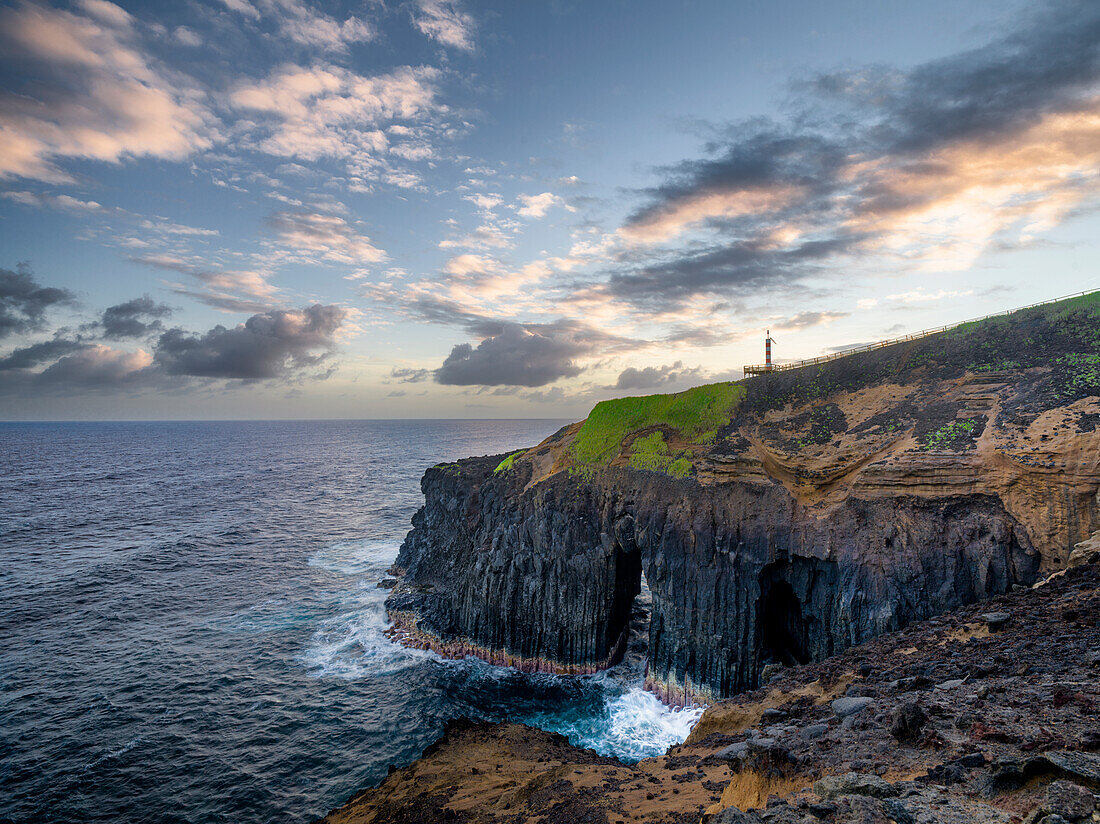Klippe über dem Meer, mit einem natürlichen Bogen und kleinem Leuchtturm, Farolim dos Fenais da Ajuda, Insel Sao Miguel, Azoren, Portugal, Atlantischer Ozean, Europa