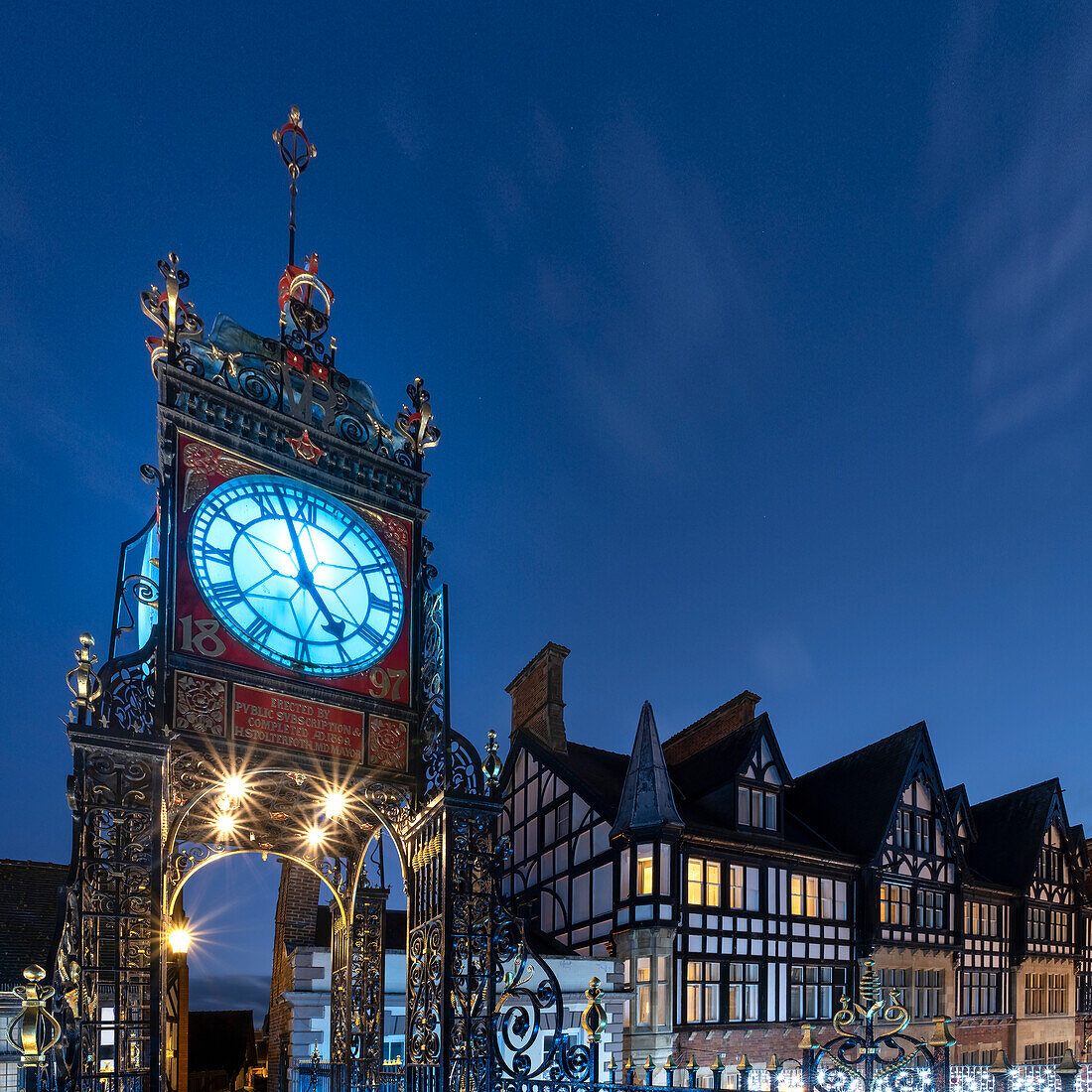 Die viktorianische Eastgate-Uhr an der Stadtmauer bei Nacht, Eastgate Street, Chester, Cheshire, England, Vereinigtes Königreich, Europa