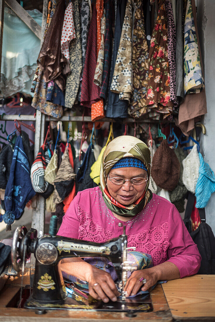 Nähende Frau auf dem Markt von Berastagi (Brastagi), Nordsumatra, Indonesien