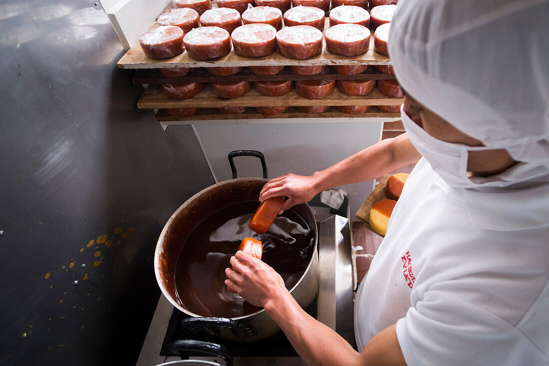 Waxing cheese at the Cheese Factory on the farm at Hacienda Zuleta, Imbabura, Ecuador, South America