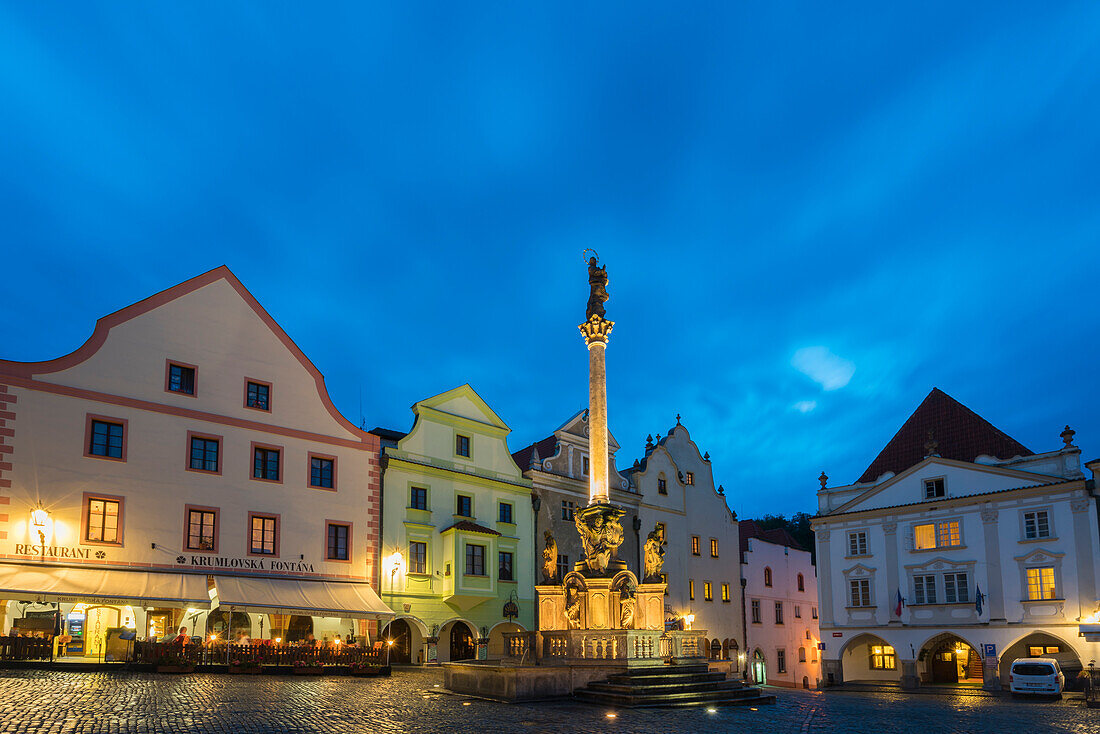 Fountain and Plague Column and traditional houses with gables in background at twilight, Namesti Svornosti Square in historical center, UNESCO, Cesky Krumlov, Czech Republic (Czechia), Europe